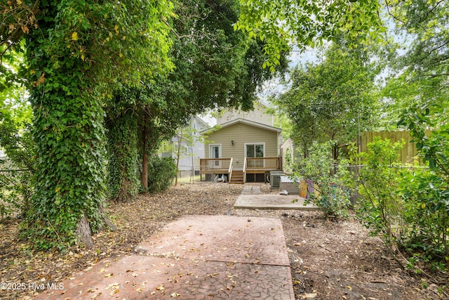 view of yard with fence, central air condition unit, a patio, and a wooden deck