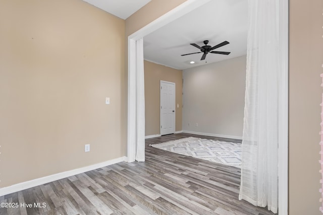 empty room featuring wood finished floors, recessed lighting, a ceiling fan, and baseboards