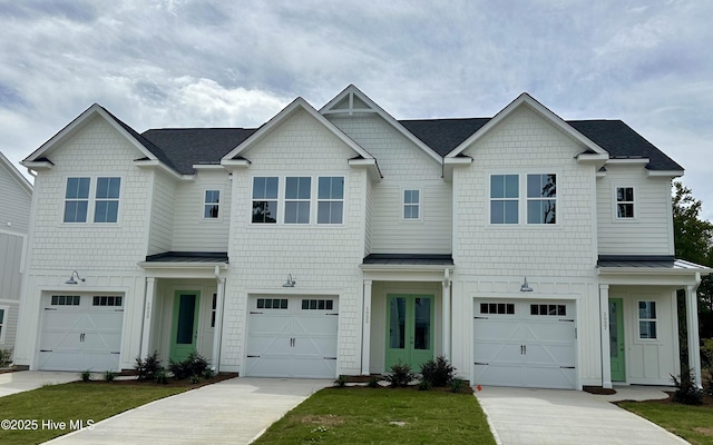 multi unit property with concrete driveway, a garage, board and batten siding, and a standing seam roof