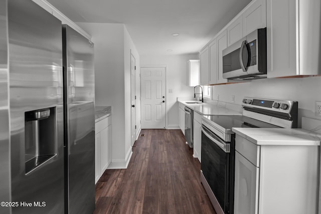 1107 Adams St N, Wilson, NC 27893 - kitchen with appliances with stainless steel finishes, dark wood-style flooring, a sink, white cabinetry, and baseboards