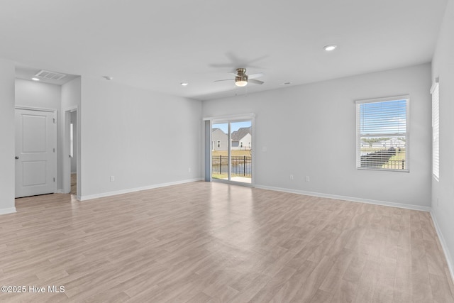 spare room with a ceiling fan, visible vents, a healthy amount of sunlight, and light wood-style flooring