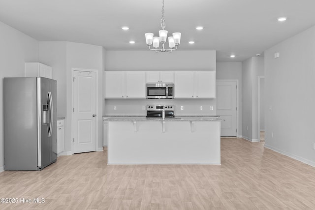 kitchen featuring white cabinets, stainless steel appliances, and light wood-type flooring