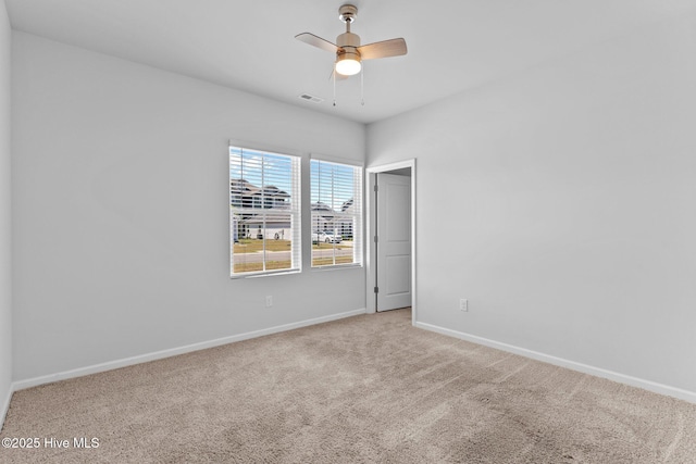 empty room featuring baseboards, a ceiling fan, and carpet flooring