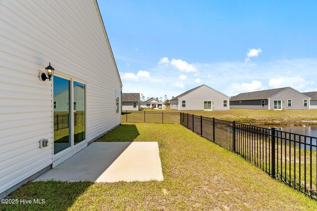 view of yard with a residential view, a fenced backyard, and a patio area