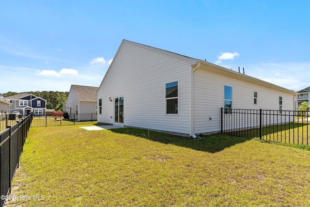 rear view of property with a fenced backyard and a yard