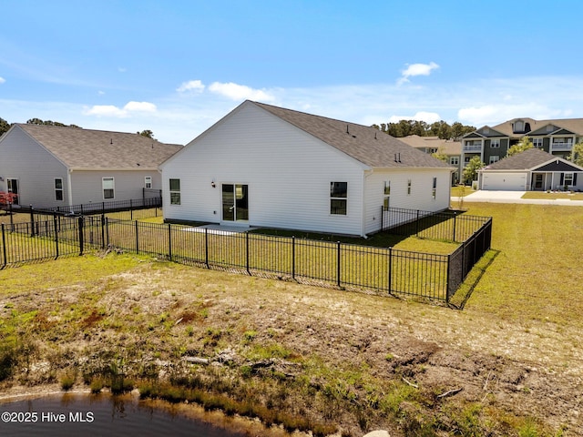 back of house featuring a lawn, a shingled roof, a residential view, and a fenced backyard