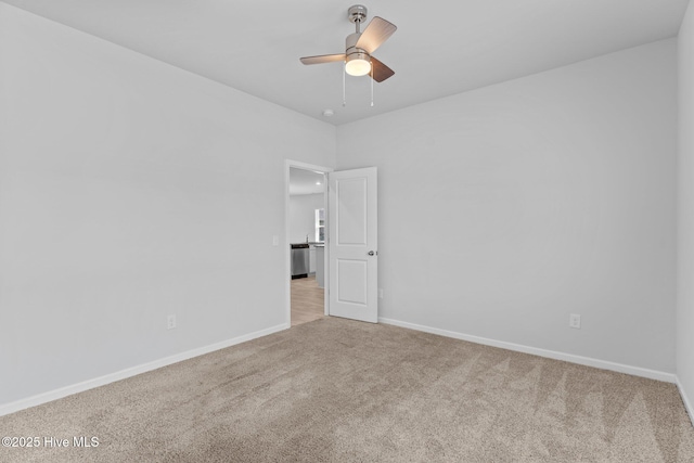 spare room featuring carpet flooring, ceiling fan, and baseboards