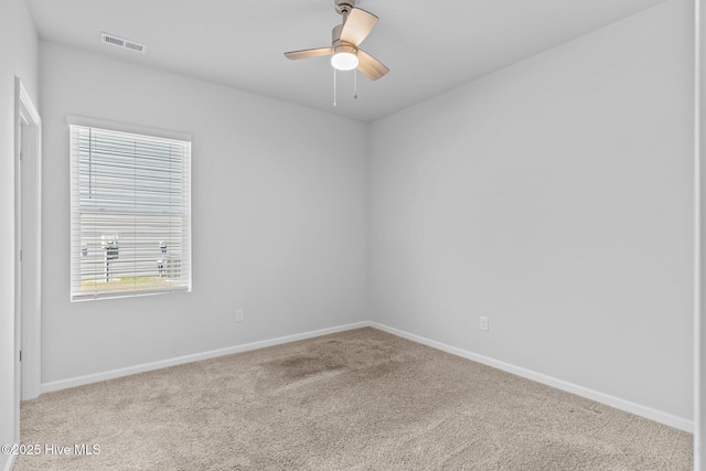 carpeted empty room featuring baseboards, ceiling fan, and visible vents