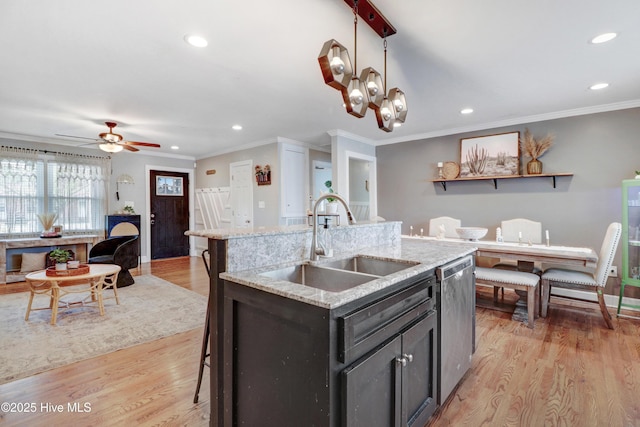 kitchen with recessed lighting, stainless steel dishwasher, light wood-style floors, and a sink
