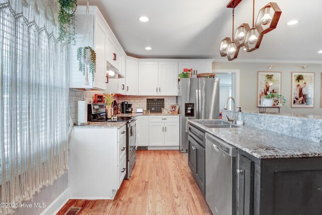 kitchen featuring under cabinet range hood, light wood-type flooring, appliances with stainless steel finishes, and white cabinetry