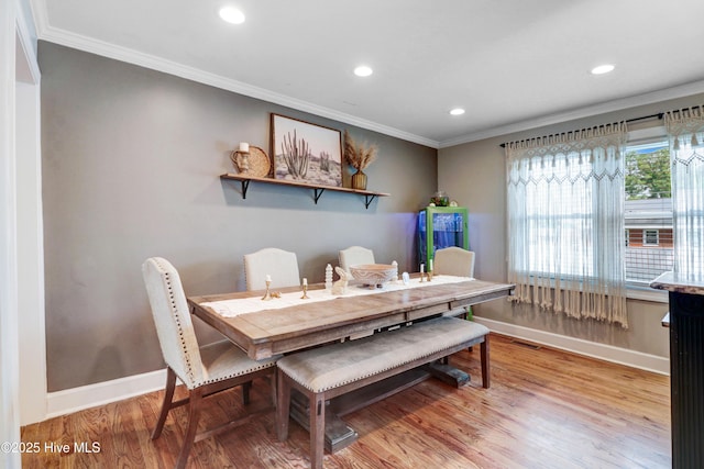 dining area featuring light wood-style floors, recessed lighting, ornamental molding, and baseboards