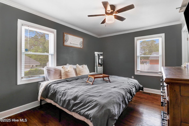 bedroom featuring ornamental molding, multiple windows, and wood finished floors