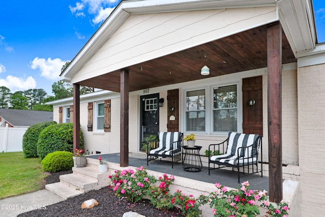 doorway to property with covered porch and brick siding
