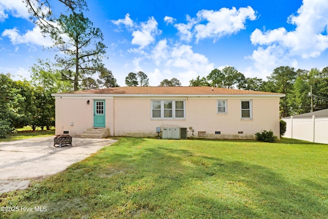 back of house with a yard, a fire pit, fence, entry steps, and crawl space