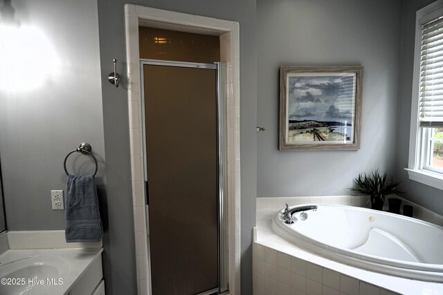 bathroom featuring vanity, a bath, and a stall shower