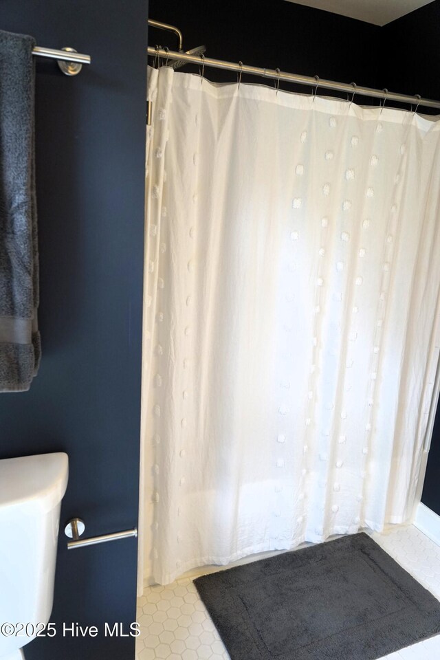bathroom with toilet and tile patterned floors