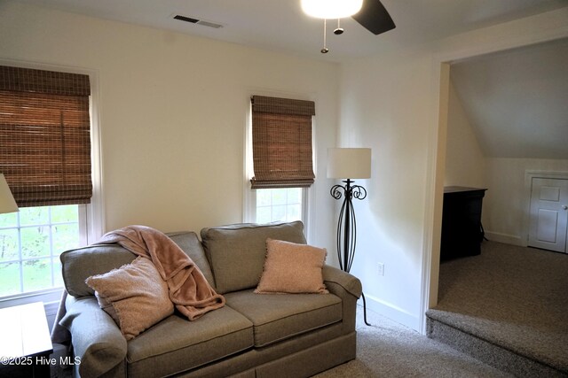 carpeted living area with a ceiling fan, baseboards, visible vents, and plenty of natural light