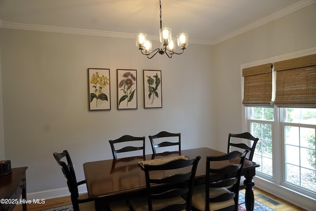dining space featuring visible vents, ornamental molding, wood finished floors, baseboards, and a notable chandelier
