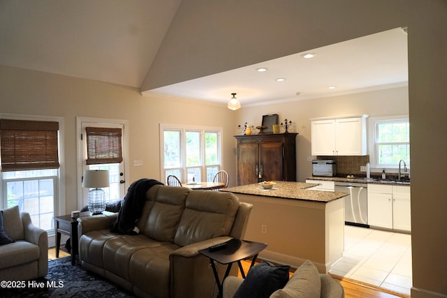 living area featuring recessed lighting, lofted ceiling, ornamental molding, and light wood finished floors