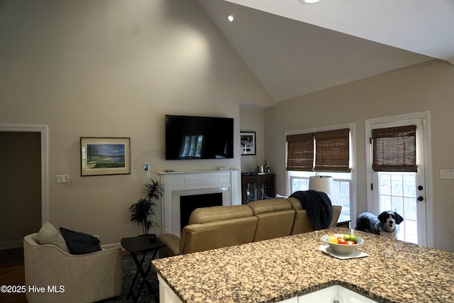 dining space with a fireplace, baseboards, high vaulted ceiling, recessed lighting, and dark wood-type flooring