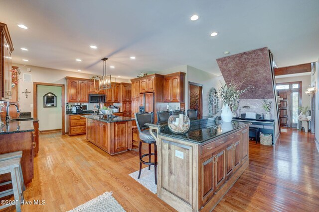 753 S Horsepen Dr, Harrells, NC 28444 - kitchen with a center island, a sink, light wood-style floors, and stainless steel microwave