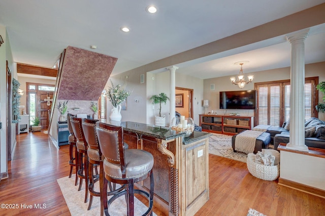 753 S Horsepen Dr, Harrells, NC 28444 - kitchen with light wood finished floors, a breakfast bar area, and ornate columns