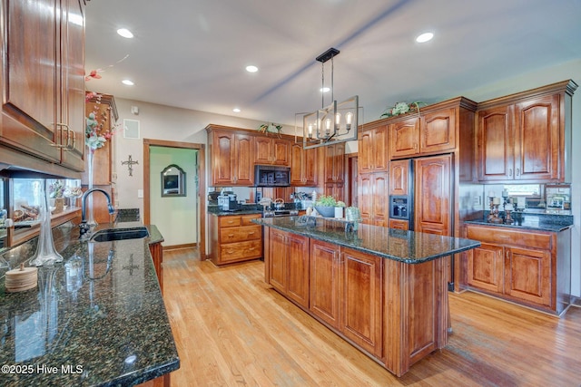 753 S Horsepen Dr, Harrells, NC 28444 - kitchen with a kitchen island, paneled built in fridge, dark stone countertops, a sink, and light wood-style flooring