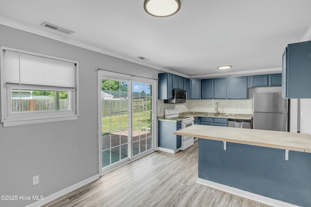 kitchen with a kitchen breakfast bar, visible vents, stainless steel appliances, and blue cabinets