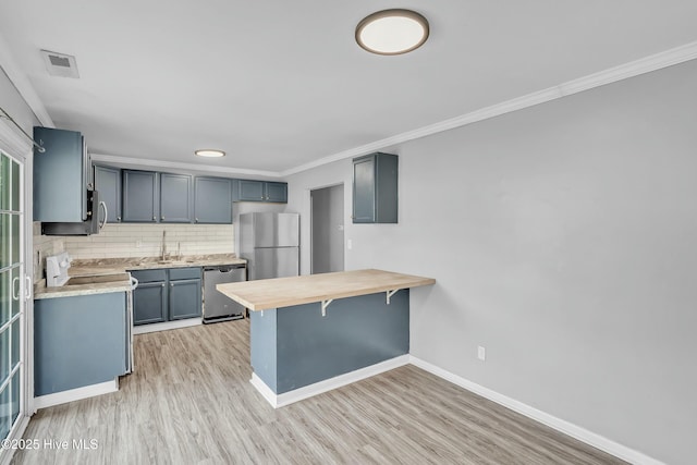 kitchen with a breakfast bar, visible vents, a peninsula, baseboards, and appliances with stainless steel finishes