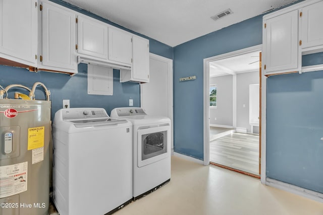 clothes washing area featuring cabinet space, separate washer and dryer, visible vents, water heater, and baseboards
