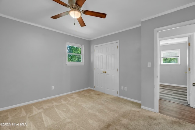 unfurnished bedroom with baseboards, carpet floors, and multiple windows