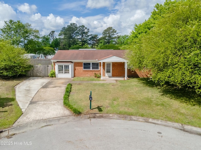 view of front of home featuring a front yard, fence, driveway, and brick siding