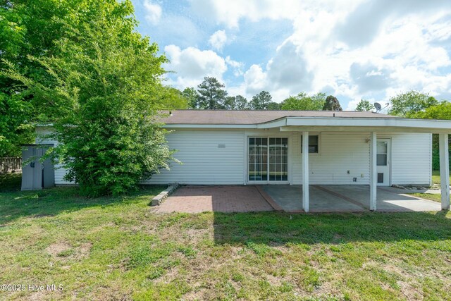 rear view of house featuring a patio and a yard