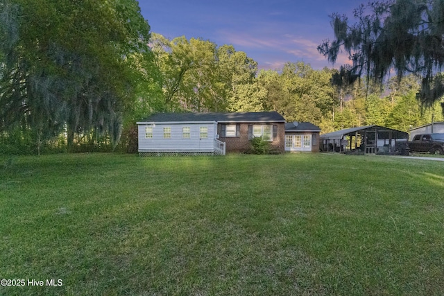 view of front of property featuring brick siding and a yard