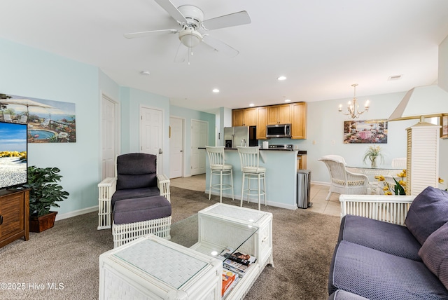 living room featuring light colored carpet, baseboards, and ceiling fan with notable chandelier