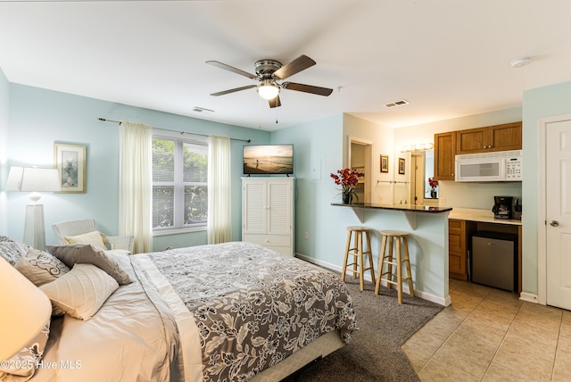bedroom featuring light tile patterned flooring, visible vents, a ceiling fan, and baseboards