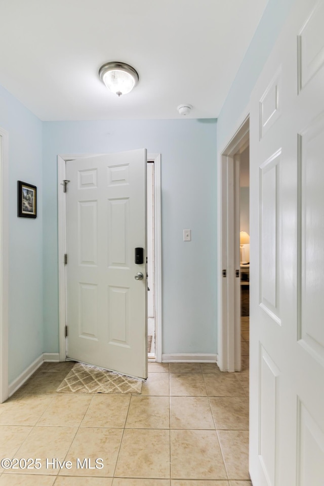 entryway with light tile patterned floors and baseboards
