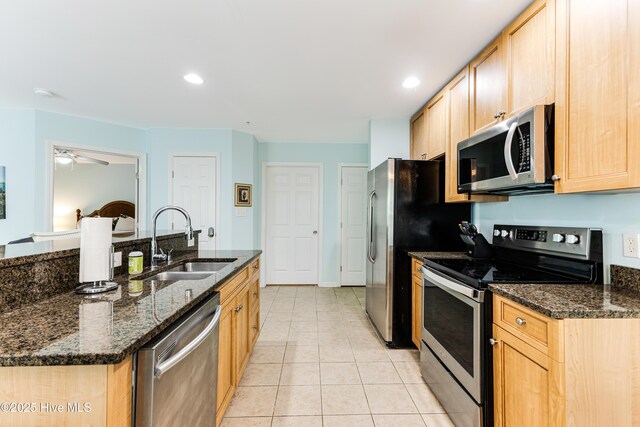 kitchen featuring a sink, light brown cabinets, light tile patterned floors, a ceiling fan, and appliances with stainless steel finishes
