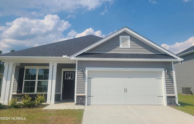 78 Fishing Creek Dr, New Bern, NC 28562 - view of front of home with central AC unit, stone siding, driveway, and a garage