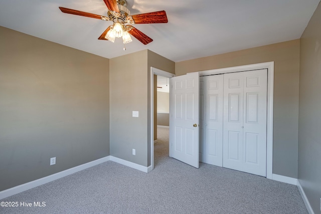 unfurnished bedroom featuring baseboards, carpet, and a closet