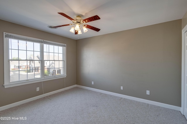 carpeted empty room featuring baseboards and ceiling fan