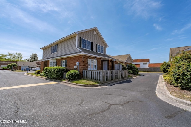 view of front of house with brick siding and fence