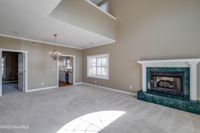 unfurnished living room featuring ornamental molding, carpet flooring, a chandelier, and visible vents
