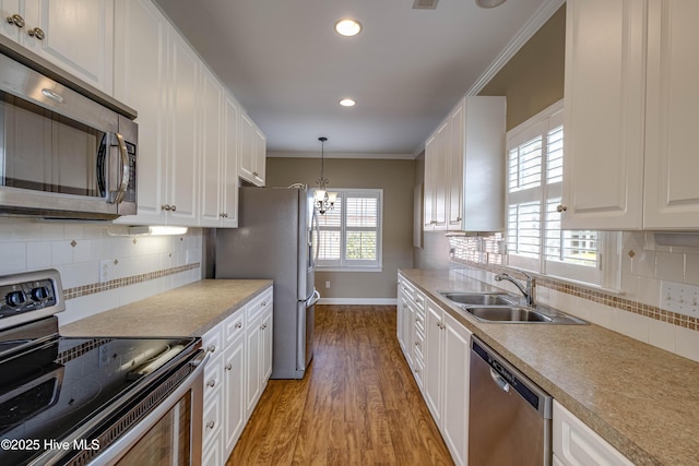 kitchen featuring a sink, stainless steel appliances, light wood-style flooring, and white cabinetry