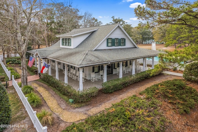 9148 E Lake Rd, Calabash, NC 28467 - country-style home featuring roof with shingles, a porch, and a patio area
