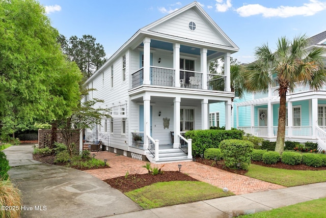 greek revival inspired property with a balcony and a porch