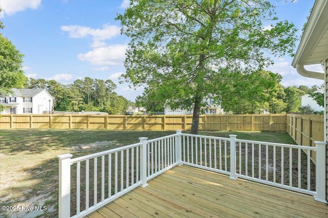 wooden terrace with a lawn and a fenced backyard