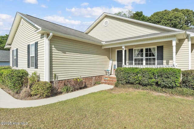 ranch-style home with covered porch and a front yard