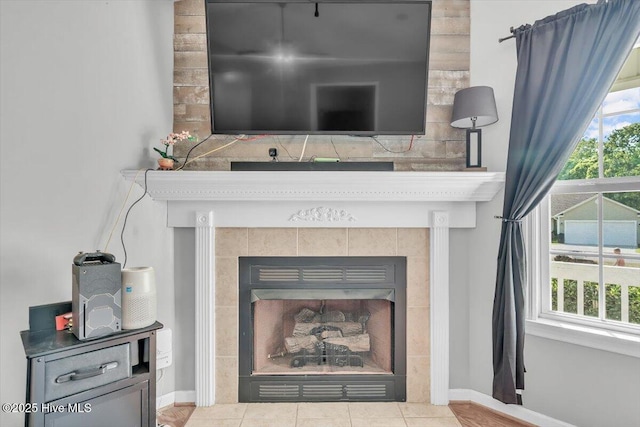 interior details with baseboards and a tile fireplace
