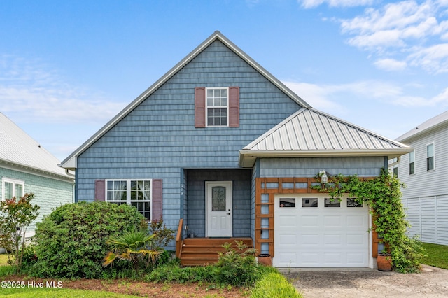 view of front of property featuring driveway, metal roof, and an attached garage